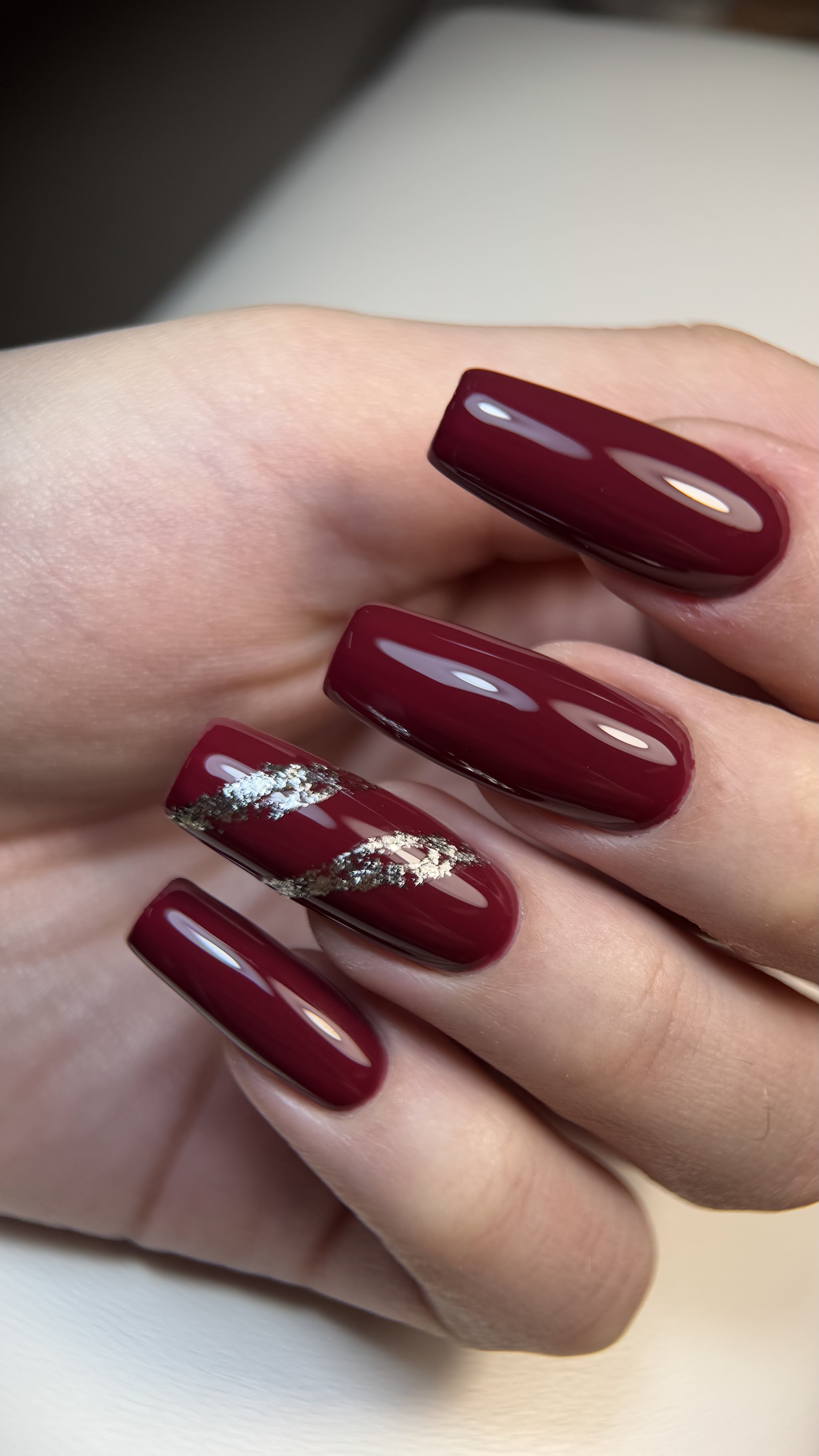 Lange bordeauxrode nagels met een folie-accent